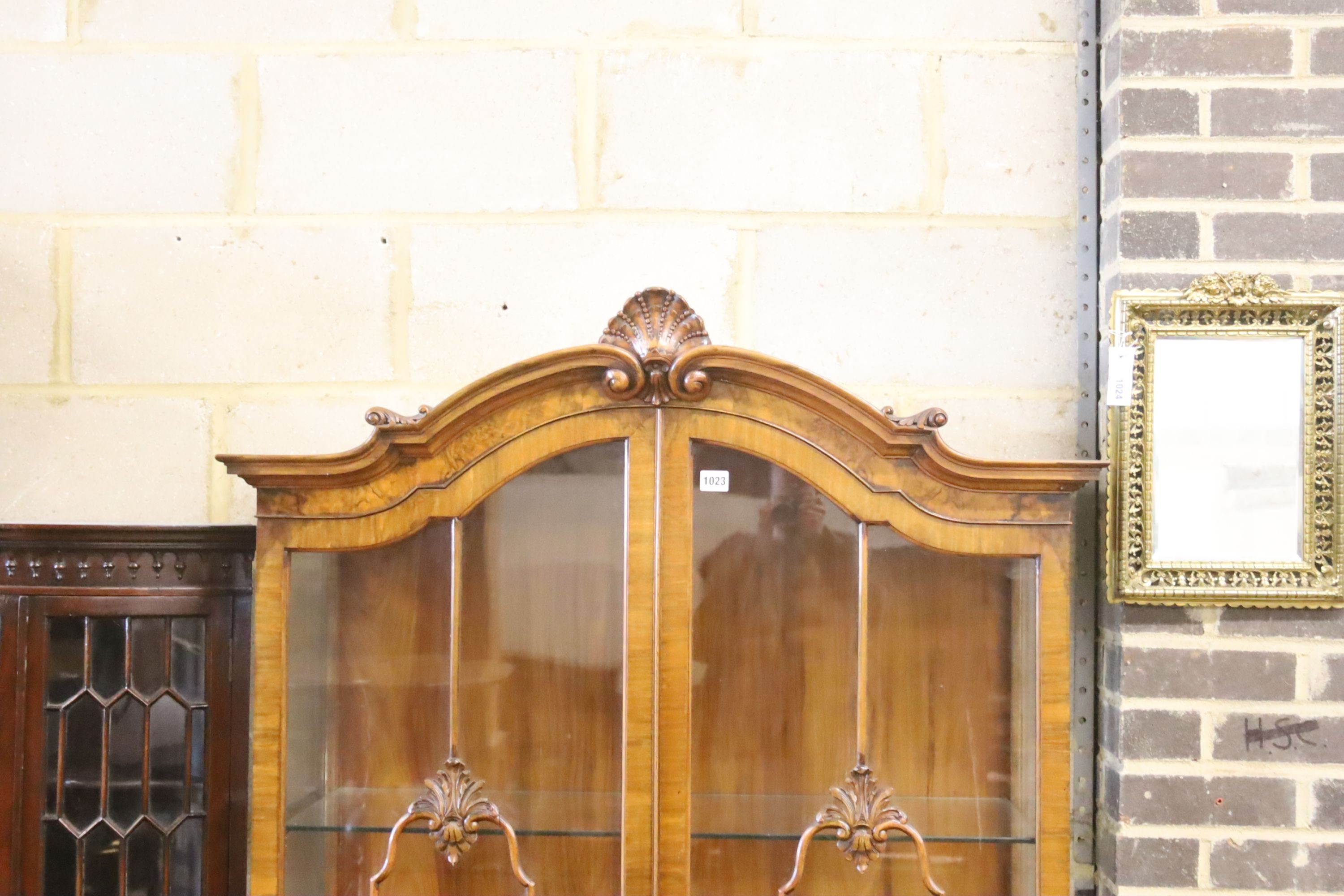 A George I style figured walnut display cabinet with glazed doors on cabriole supports and scrolled legs, width 100cm, depth 40cm, height 192cm